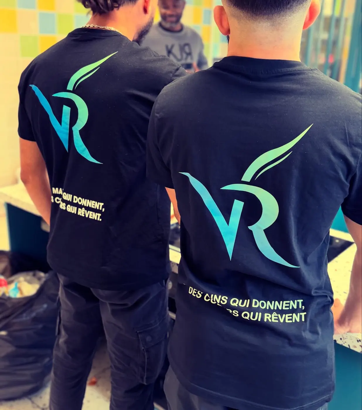 Deux bénévoles de dos, le logo VivoRêve sur leurs sweats