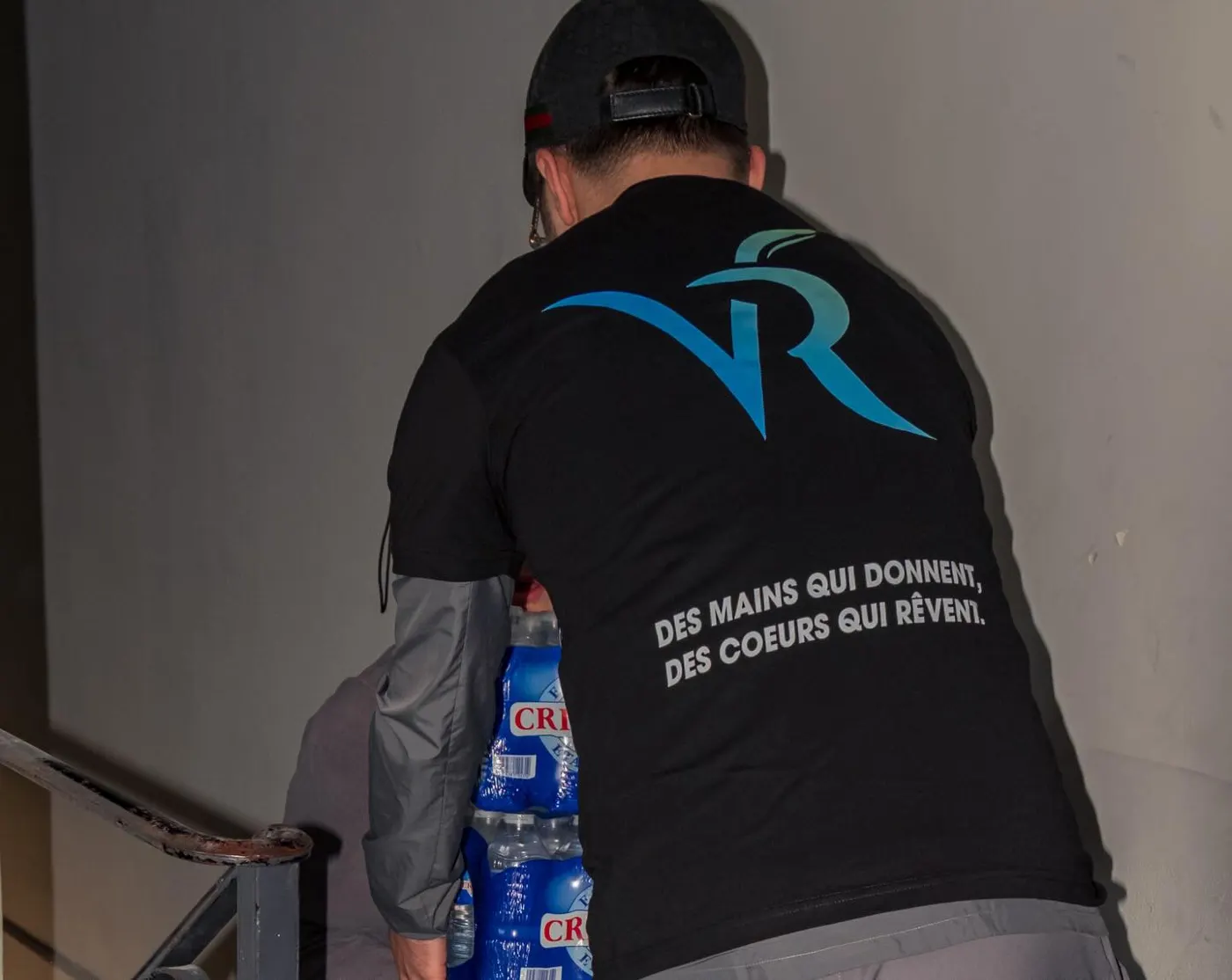 Un bénévole de VivoRêve décharge des packs d’eau d’une camionnette